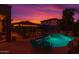 Relax by the pool with a lush waterfall feature and outdoor seating under the covered patio, perfect for evening relaxation at 838 E Nolan Pl, Chandler, AZ 85249