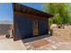Backyard outbuilding with board and batten siding features a brown wood door at 846 N 81St St, Mesa, AZ 85207