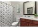 Bright bathroom featuring single sink, wood cabinets, patterned shower curtain, and plantation shutters at 919 W Yellowstone Way, Chandler, AZ 85248
