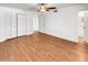 A bright bedroom featuring wood-look floors, a ceiling fan, and a double door closet at 920 E Garnet Ave, Mesa, AZ 85204