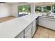 The kitchen features a large island with white countertops and views of the landscaped backyard at 920 E Garnet Ave, Mesa, AZ 85204