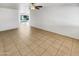 Spacious living room featuring tile flooring, a ceiling fan, and bright natural light with a view to the pool at 920 E Garnet Ave, Mesa, AZ 85204
