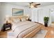This main bedroom features a ceiling fan, natural light, and a large bed at 920 E Garnet Ave, Mesa, AZ 85204