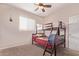 Cozy bedroom features a bunk bed, ceiling fan, and a bright window at 932 W Capulin Trl, San Tan Valley, AZ 85140