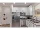 Modern kitchen with stainless steel appliances, white cabinets, granite countertops, and convenient access to living area at 932 W Capulin Trl, San Tan Valley, AZ 85140