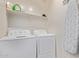 Well-organized laundry room with washer, dryer, storage shelf and ironing board at 932 W Capulin Trl, San Tan Valley, AZ 85140