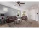 Inviting living room with a brown sofa, ceiling fan, and neutral-toned decor at 932 W Capulin Trl, San Tan Valley, AZ 85140