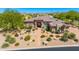 Aerial view of a charming desert home featuring lush landscaping, tile roof, and a paved walkway at 9534 E Monument Dr, Scottsdale, AZ 85262
