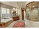 Luxurious bathroom with a soaking tub and a walk-in shower with a glass enclosure at 9534 E Monument Dr, Scottsdale, AZ 85262