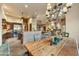 Open-concept dining area with rustic wooden table, ornate chandelier, and views of the kitchen and living spaces at 9534 E Monument Dr, Scottsdale, AZ 85262