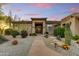 View of the front entrance with walkway and gravel landscaping with cactus, flowers, and rocks at 9534 E Monument Dr, Scottsdale, AZ 85262