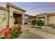View of the front entrance, walkway, and desert landscaping with flowers and cactus at 9534 E Monument Dr, Scottsdale, AZ 85262