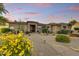 Inviting single-story home with desert landscaping, paver walkway, and a cozy covered porch, accentuated by a colorful sunset at 9534 E Monument Dr, Scottsdale, AZ 85262