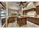 Spacious kitchen with dark wood cabinets, a center island, and stainless steel appliances at 9534 E Monument Dr, Scottsdale, AZ 85262