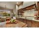 View of the kitchen with dark wood cabinets, granite countertops, and tiled backsplash at 9534 E Monument Dr, Scottsdale, AZ 85262