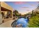 Backyard swimming pool with a waterfall feature and desert landscaping at 9534 E Monument Dr, Scottsdale, AZ 85262