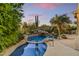 Backyard pool with natural rock waterfall, lush landscaping, and a relaxing desert ambiance at 9534 E Monument Dr, Scottsdale, AZ 85262