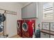 Well-equipped laundry room with striking red washer and dryer and grey cabinets at 10144 E Toledo Ave, Mesa, AZ 85212