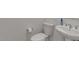 A close-up of the powder room featuring a contemporary toilet and pedestal sink at 10144 E Toledo Ave, Mesa, AZ 85212