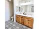 Bathroom featuring dual sinks, quartz countertop, and decorative patterned floor at 10229 N 12Th Ct # 1, Phoenix, AZ 85020