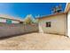 Wide shot of gravel backyard with a block wall and the home's exterior with an AC unit at 1029 E Mckinley St, Phoenix, AZ 85006