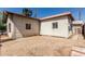 Gravel backyard with white stucco walls and barred windows under a blue sky at 1029 E Mckinley St, Phoenix, AZ 85006