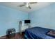 Blue bedroom features built-in shelves, a window, ceiling fan, and desk at 1029 E Mckinley St, Phoenix, AZ 85006