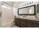 Bright bathroom with double sinks, decorative tile, and a tub with shower at 10346 E Desert Dawn Dr, Gold Canyon, AZ 85118