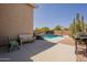 Backyard patio with a pool, chairs, and cacti, ideal for relaxation and enjoying the outdoors at 10346 E Desert Dawn Dr, Gold Canyon, AZ 85118