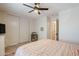 Spacious bedroom featuring a ceiling fan, dresser with a TV, large closet doors and access to the ensuite at 1145 E Lowell Ave, Gilbert, AZ 85295