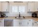 Close-up of the kitchen featuring white cabinets, countertops, stainless steel dishwasher and sink at 1145 E Lowell Ave, Gilbert, AZ 85295