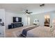 Comfortable main bedroom featuring fan, TV, vanity, and walk-in closet with carpet at 1145 E Lowell Ave, Gilbert, AZ 85295