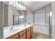 Primary bathroom featuring double sinks, a bathtub, and a glass-enclosed shower at 12441 W Windsor Blvd, Litchfield Park, AZ 85340