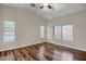 Bedroom featuring wood-look floors, neutral walls, a ceiling fan, and natural light from multiple windows at 12441 W Windsor Blvd, Litchfield Park, AZ 85340