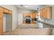 Kitchen features wood cabinets, granite countertops, stainless steel appliances, and tiled flooring at 12441 W Windsor Blvd, Litchfield Park, AZ 85340