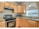 Bright kitchen with granite countertops, wood cabinets, stainless steel appliances, and natural light at 12441 W Windsor Blvd, Litchfield Park, AZ 85340
