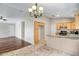Open-concept kitchen and dining area with granite countertops, wood cabinets, and a chandelier at 12441 W Windsor Blvd, Litchfield Park, AZ 85340