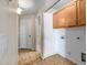 Well-lit laundry room features ample cabinet storage and tile flooring at 12441 W Windsor Blvd, Litchfield Park, AZ 85340