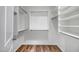 Walk-in closet with built-in shelving, hanging rods, and wood-look flooring at 12441 W Windsor Blvd, Litchfield Park, AZ 85340