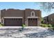Exterior shot of garage with decorative rock and brown doors, set in a sunny neighborhood at 13300 E Via Linda Dr # 1058, Scottsdale, AZ 85259