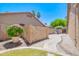 Backyard with stone landscaping, flowering plant and privacy wall and palm trees at 1470 W Bartlett Way, Chandler, AZ 85248