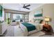 Staged bedroom featuring a calming color palette, carpet floors, ceiling fan, and large windows with backyard views at 1470 W Bartlett Way, Chandler, AZ 85248