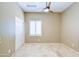 Bedroom featuring neutral walls, stone floors, a ceiling fan, and a window with plantation shutters at 1470 W Bartlett Way, Chandler, AZ 85248