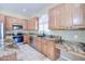 Kitchen featuring wood cabinets, granite counters, stainless appliances, and a built-in desk area at 1470 W Bartlett Way, Chandler, AZ 85248