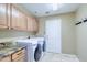 Functional laundry room with modern washer and dryer, granite countertops, and ample cabinet space for storage at 1470 W Bartlett Way, Chandler, AZ 85248