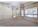 Open living room with multiple windows and neutral carpet at 1470 W Bartlett Way, Chandler, AZ 85248