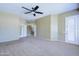 Large bedroom with neutral carpet, a ceiling fan, and a glass door to the outside at 1470 W Bartlett Way, Chandler, AZ 85248