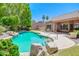 Inviting pool and spa area with rock features, patio, and meticulously manicured landscaping at 1470 W Bartlett Way, Chandler, AZ 85248