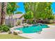 Lush backyard with freeform pool surrounded by mature trees and grass at 1470 W Bartlett Way, Chandler, AZ 85248
