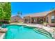Inviting backyard pool with stone accents, landscaped surroundings, and covered patio at 1470 W Bartlett Way, Chandler, AZ 85248